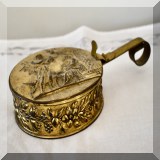 D54. Brass ash box with man woman and child relief on top. 2”h x 8”w - $10 